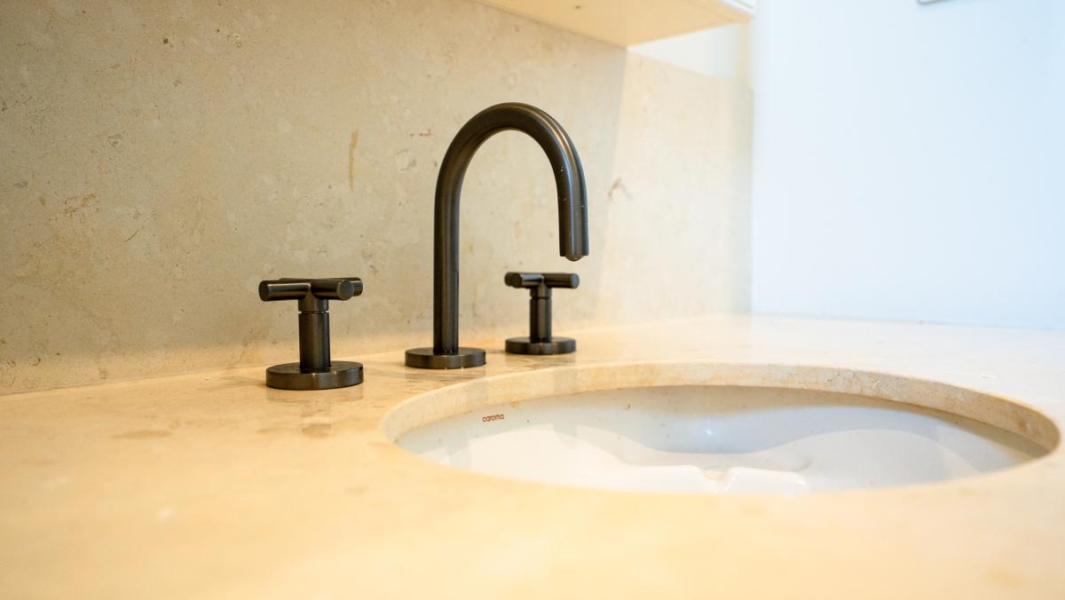 Luxury bathroom renovation featuring black tapware and marble benchtop with undermount basin