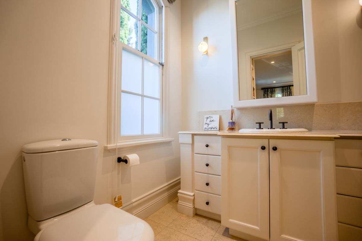 Modern bathroom renovation with white vanity, marble countertop, and large window with natural light