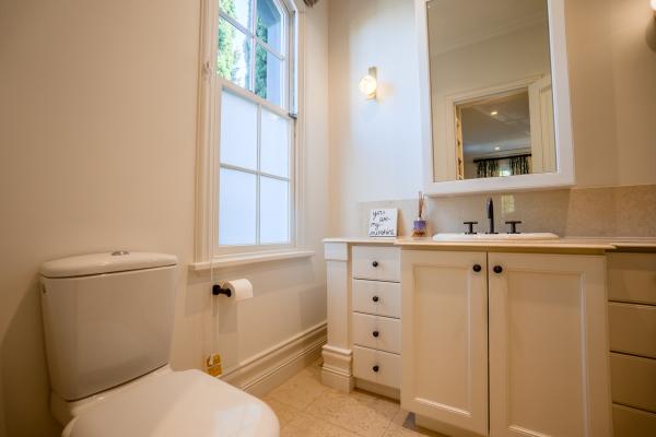 Modern bathroom renovation with white vanity, marble countertop, and large window with natural light