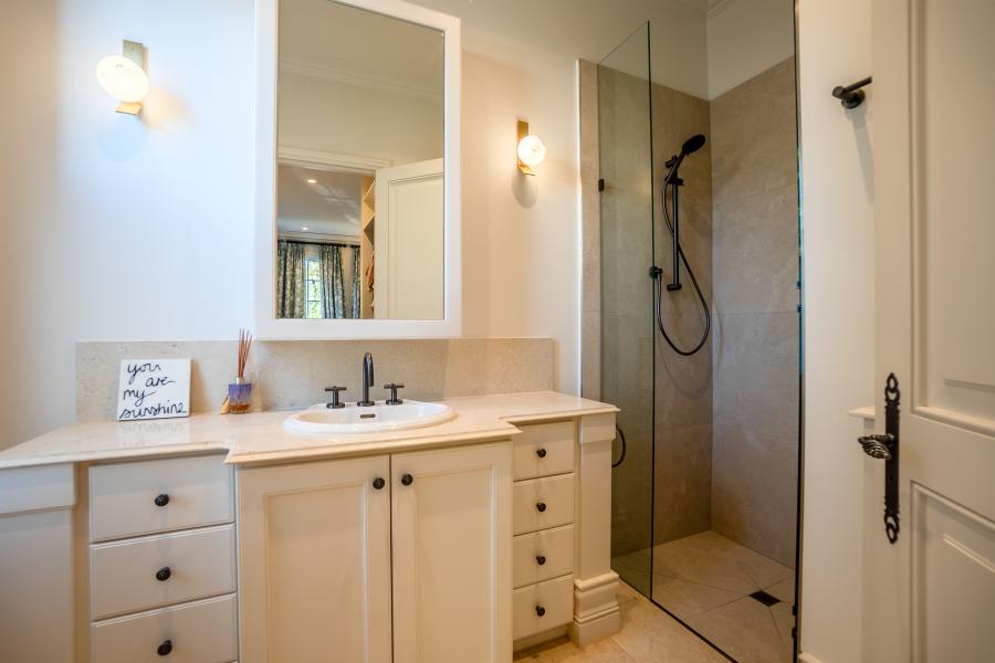 Luxury bathroom renovation with white vanity, illuminated mirror, glass shower screen and modern fixtures