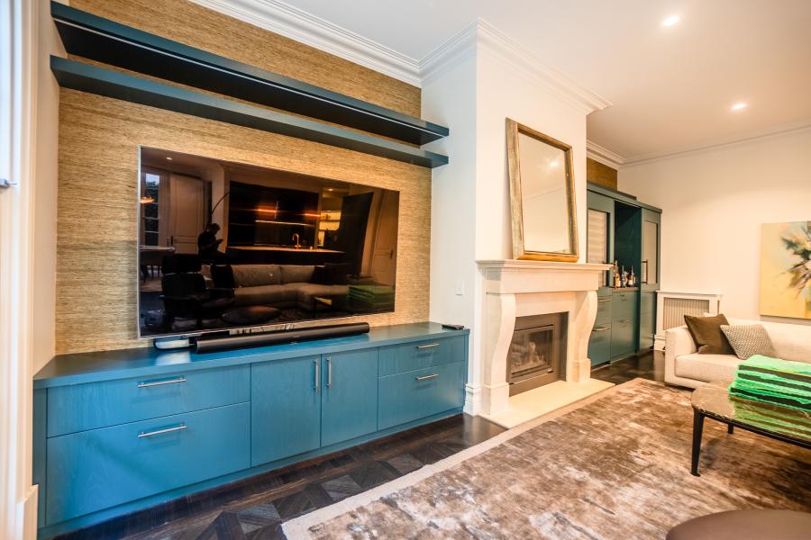 Luxury modern living room with bespoke blue media unit, floating shelves, and classic fireplace mantel