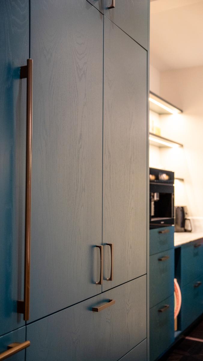 Modern luxury kitchen cabinets with light wood grain finish and copper handles in contemporary design