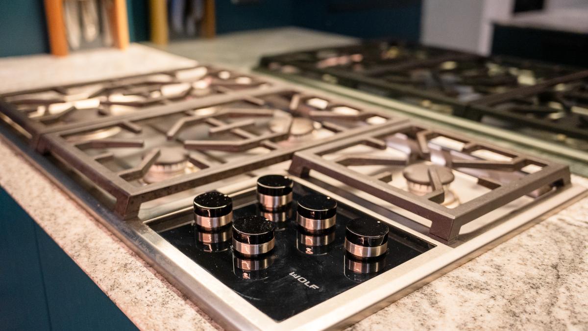 Premium gas cooktop with dual Wolf induction modules built into granite kitchen benchtop in luxury Melbourne home
